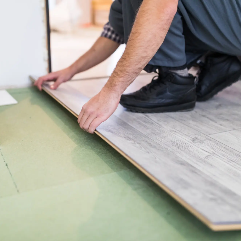 worker-processing-floor-with-laminated-flooring-boards-copia